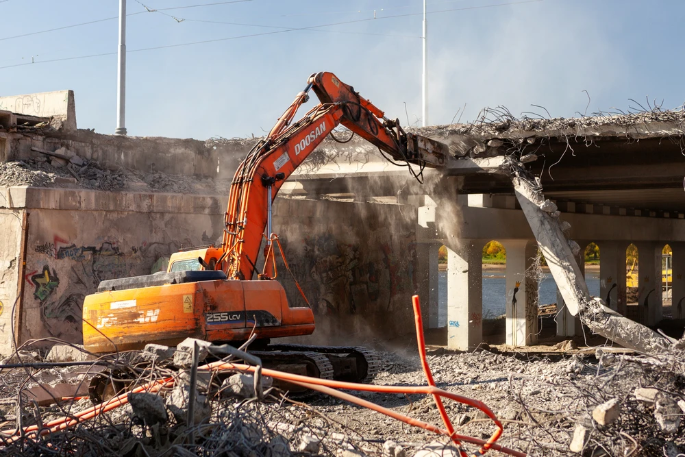 Chantier de démolition en extérieur avec pelleteuses hydrauliques sur chenilles détruisant des bâtiments résidentiels